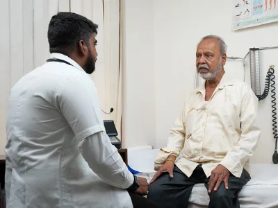 A patient checking in with a clinician at a front desk
