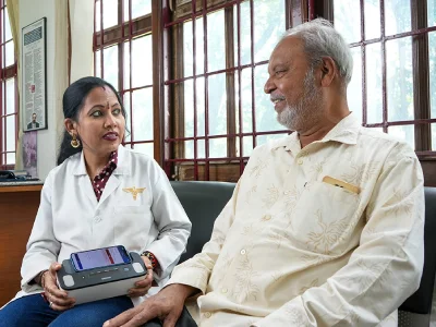 A patient checking in with a clinician at a front desk