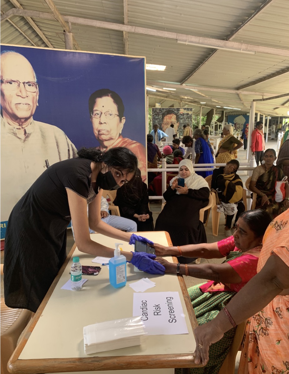 A health worker capturing a Tricog CardioCheck reading at the cardiac risk screening desk in a village clinic